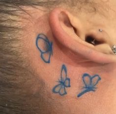 a close up of a person with butterfly tattoos on their behind the ear