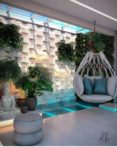 an outdoor living area with hanging chairs and plants on the wall, along with a water feature