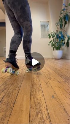 a person riding a skateboard on top of a hard wood floor in a room