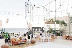 an outdoor dining area overlooking the ocean with lots of tables and chairs set up for dinner