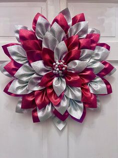 a large red and silver flower hanging from the side of a door