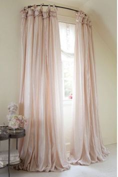 an image of a window with curtains in the middle and pink drapes hanging from it