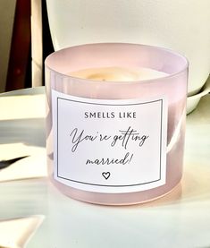 a candle that is sitting on a table with a card in front of it saying smells like you're getting married