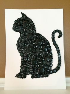 a black cat made out of buttons on a white card