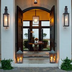 the front entrance to a hotel with two large planters and lights on either side