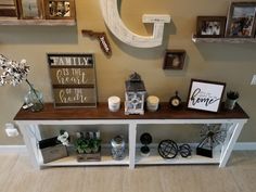 a shelf with some pictures and other items on it next to a wall mounted letter