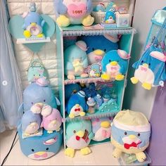 there are many stuffed animals on the shelves in this room, and one is blue