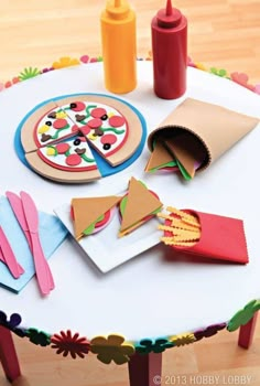 a table topped with paper cutouts and pizza slices