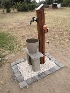 a fire hydrant sitting next to a wooden pole with a bucket on it's side