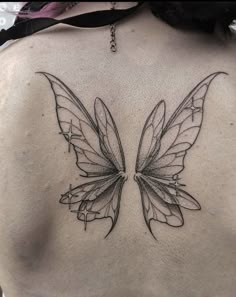 a woman's back with a butterfly tattoo on it