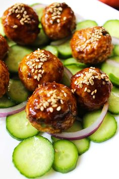 meatballs and cucumbers on a plate with sesame seeds