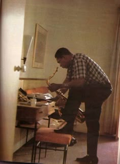 a man playing the saxophone in his home