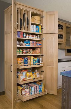 an organized pantry in the middle of a kitchen with wooden flooring and cupboards