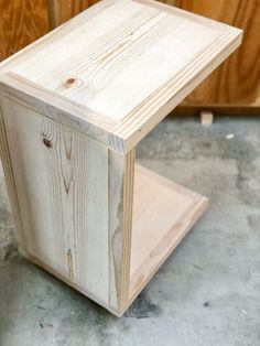 a wooden box sitting on top of a floor next to some wood planks and plywood