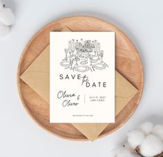 a save the date card sitting on top of a wooden plate next to cotton balls