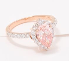 an engagement ring with a pink diamond surrounded by white and rose gold diamonds, on a white background