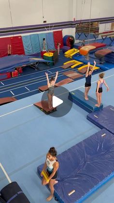 some people are doing gymnastics on blue mats