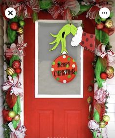 the grinch door decoration is decorated with christmas decorations and wreaths on red front door