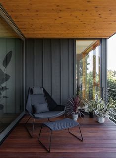 a chair sitting on top of a wooden floor next to a plant filled potted plant