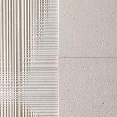 a white tile wall with lines and dots on the bottom, in two different colors