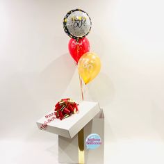 a white box with some balloons in it