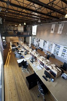 an open office with lots of desks and books on the shelves in front of them