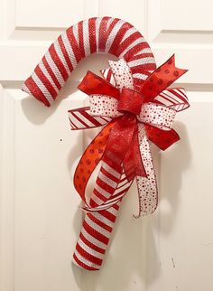 a red and white candy cane wreath hanging on a door