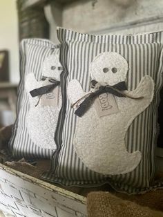 two decorative pillows with ghost faces on them