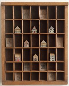 a wooden shelf filled with miniature houses on top of it