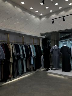 a clothing store with clothes on display in the window and lights hanging from the ceiling