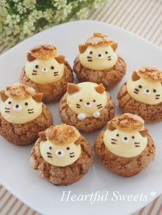 there are many cookies with cats on top of each cookie, and one has cream frosting in the shape of a cat's head