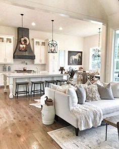 a living room filled with furniture next to a kitchen