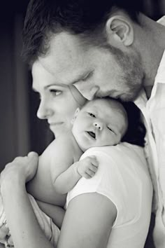 a man and woman holding a baby in their arms with the caption's name on it