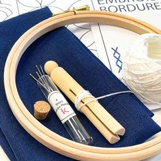 two wooden dowels are sitting on top of a blue piece of fabric next to a ball of yarn