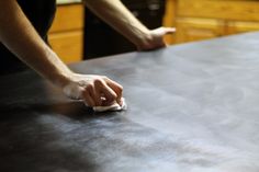 a person wiping down the top of a table