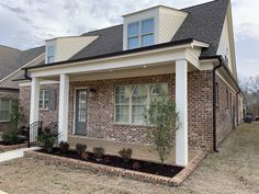 a brick house with white trim and black roof