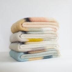 a stack of folded blankets sitting on top of each other in front of a white background