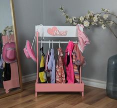 there is a pink rack with clothes on it