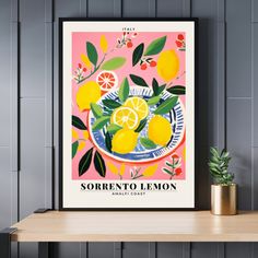 a poster with lemons and leaves on a table next to a potted plant