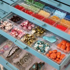 a drawer filled with lots of different types of beads and other things in plastic containers