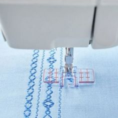 the sewing machine is working on the fabric with it's thread spools