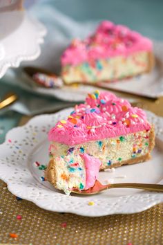 a slice of cake with pink frosting and sprinkles on a plate