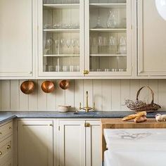 a kitchen filled with lots of white cupboards and counter top next to a sink