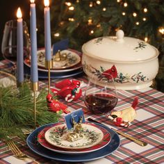 a christmas table setting with candles and plates