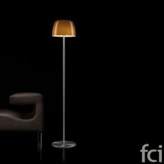 a lamp that is on top of a table next to a chair in the dark