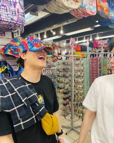 two men standing in a store with hats on their heads