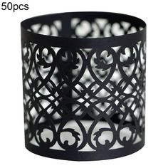 a black candle holder with an intricate design on the top and bottom, which is cut out