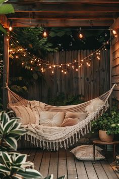 a hammock with lights hanging from it and some potted plants in the background