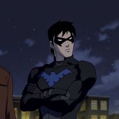 batman and robin wayne standing in front of a building at night with their arms crossed