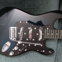 a black electric guitar with stars on it